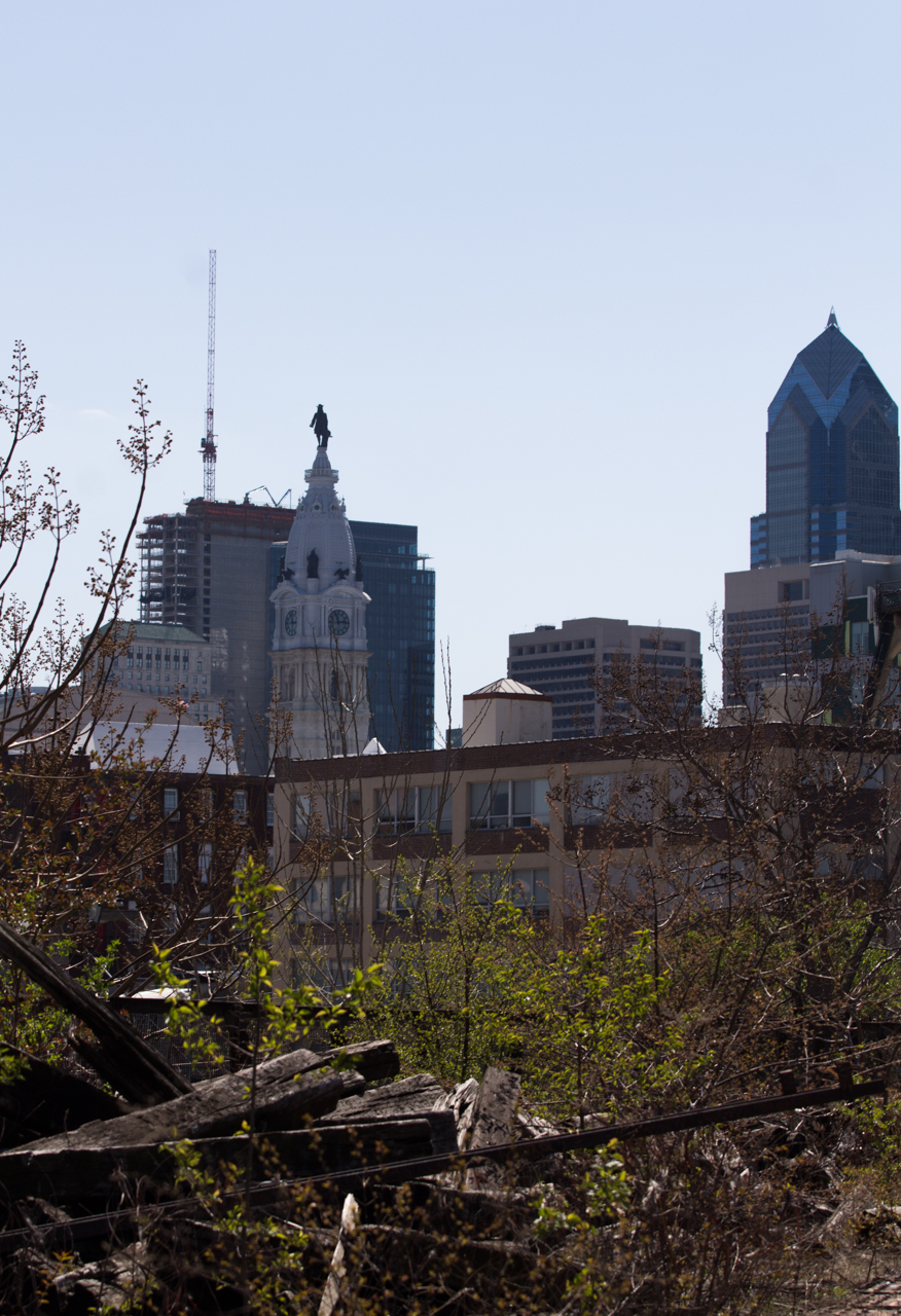 Center City’s skyscrapers overlook piles of railroad ties that sit overgrown at the southern end of the Reading Viaduct.